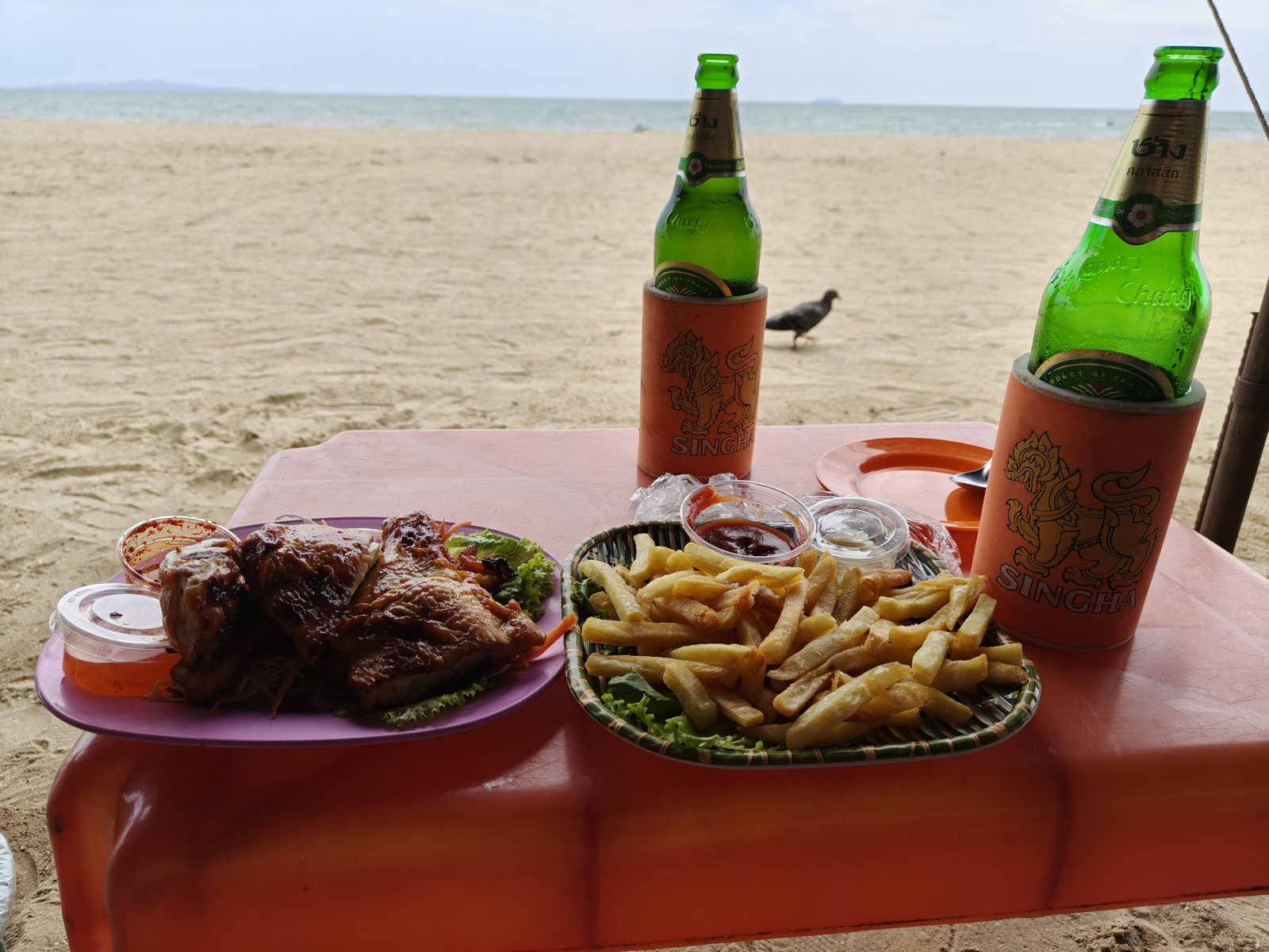 海を背景に並ぶ料理とビール
