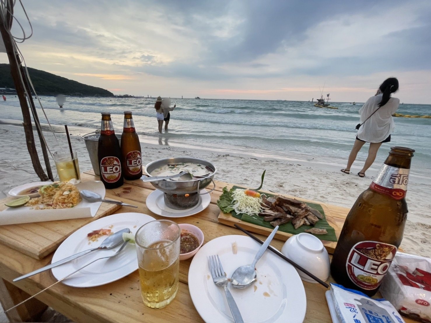 夕暮れの波打ち際と料理、ビール
