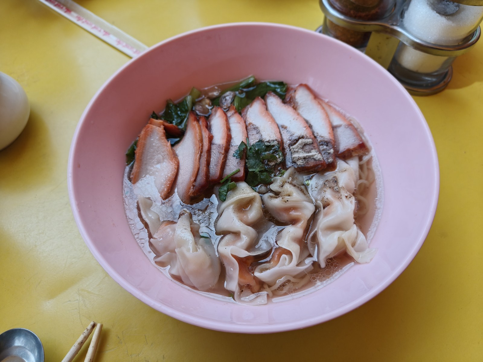 ワンタン状の具と肉をのせた一杯。器の色とスープの種類は別です。